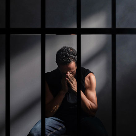 Hombre sentado en una celda